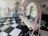 une photo d'un salon de coiffure avec un sol en damier