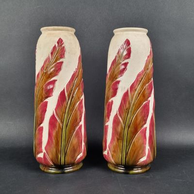 une paire de vases décorés de feuilles rouges et vertes