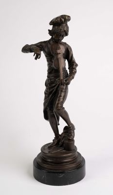 statue en bronze d'un garçon tenant un oiseau, posée sur un socle