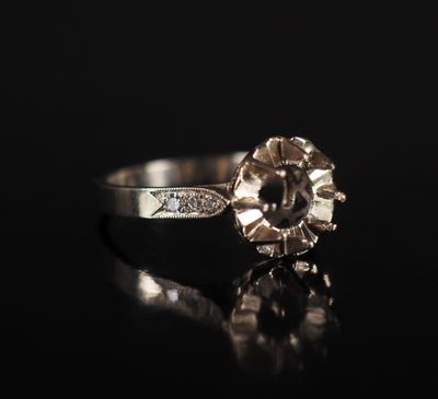 a close up of a diamond ring on a black surface