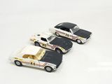 three toy cars sitting next to each other on a white surface