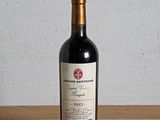 une bouteille de vin rouge posée sur une table en bois