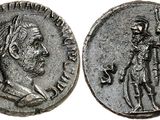 a silver coin with a man holding a spear and a sword