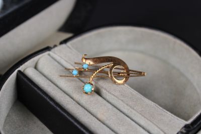 une bague en or sertie d'une turquoise, présentée dans un écrin