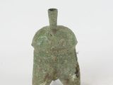 an ancient bronze helmet with a pointed face on a white background