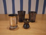 four cups sitting on a wooden table with a striped wall behind them