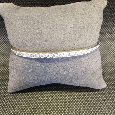 un gros plan sur un oreiller sur lequel repose un bracelet en argent