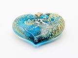 a heart shaped glass pendant with a blue and gold design on it
