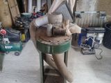 a statue of a man sitting on a stool in a garage