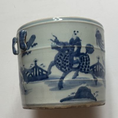 un vase bleu et blanc représentant un homme à cheval