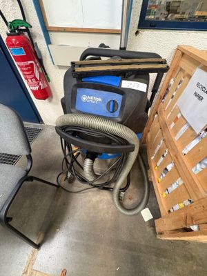 a dust collector and a chair in a room