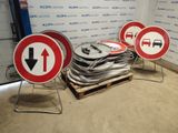 several red and white signs sitting on top of a pallet in front of a wall
