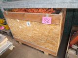 une caisse de carottes posée sur une palette dans un entrepôt