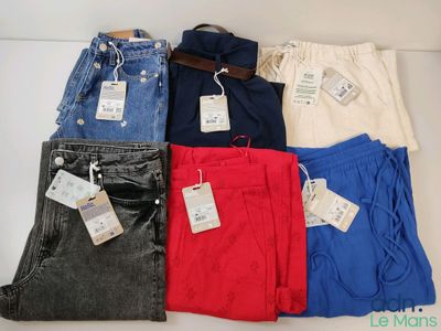 Cinq paires de jeans pour homme sont disposées sur une surface blanche