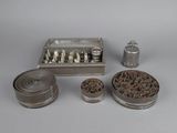 an image of a collection of metal objects including a pepper shaker, a tin canister, and a tray