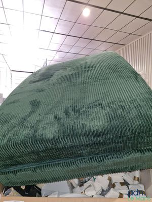 une chaise verte qui se trouve dans une pièce où il y a beaucoup de désordre