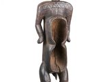 une image représentant une statue en bois d'un homme tenant un pot