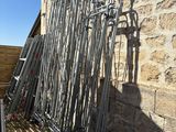 a pile of metal pipes leaning against a stone wall