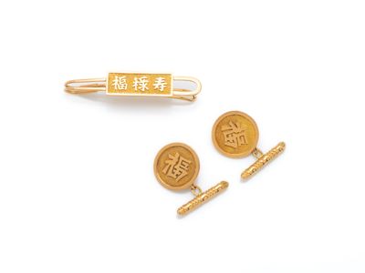 deux boutons de manchette plaqués or, ornés d'inscriptions en chinois