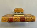 an old book sitting on top of a glass stand