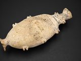 un gros plan d'un objet en forme de poisson posé sur une surface noire