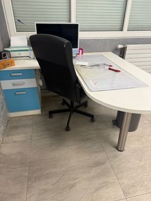 a desk with a chair and a computer on it