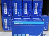 une boîte de gants d'examen en latex de qualité médicale posée sur une boîte en carton