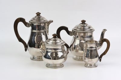 three pieces of silver tea and coffee set on a white surface