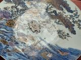 a plate with a painting on it sitting on a table