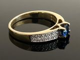 a gold ring with a blue stone and diamonds on it