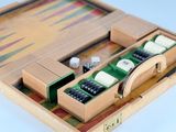 a wooden backgam board with dice and pieces in it