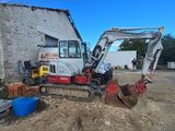 a small excavator that is parked outside of a building