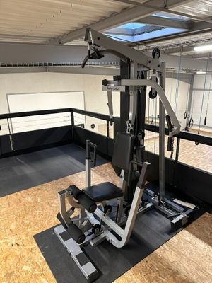une salle de sport vide avec un appareil de musculation au milieu de la pièce
