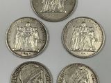 four different types of silver coins on a white surface