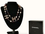un collier de perles et une boîte posée sur la table