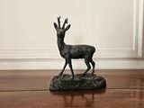 a statue of a deer standing on a wooden floor