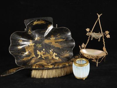 a black and gold plate with a brush and brush holder