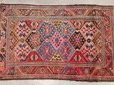 an old rug with a pink and blue design on it