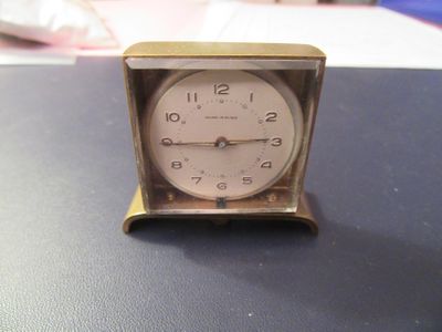 une petite horloge posée sur une table, elle-même posée sur une table