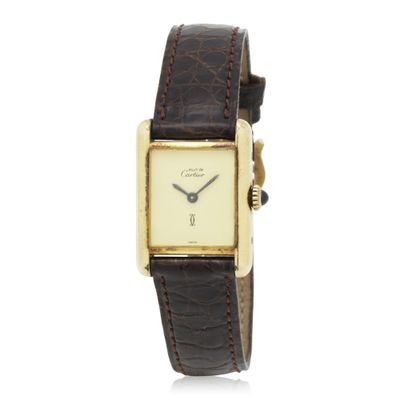 a gold plated wrist watch with a brown leather band