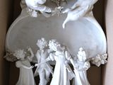 une figurine blanche dans une boîte décorée d'anges