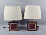 pair of red and gold table lamps with white lampshads on them