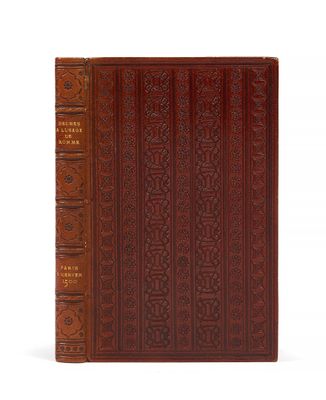 un livre en cuir marron dont la couverture est ornée de motifs complexes