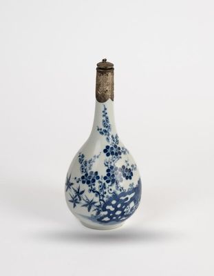 a small blue and white bottle with flowers on it
