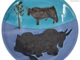 une assiette sur laquelle sont représentés une vache et un arbre
