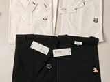 Il y a trois chemises blanches et une chemise noire sur une table