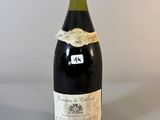 une vieille bouteille de vin posée sur une table
