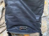 le dos d'un sac noir posé sur un bâton en bois