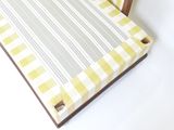 une chaise dont l'assise est à carreaux jaunes et blancs