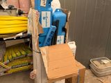 une pile de cartons et un bidon d'eau bleu posés par terre